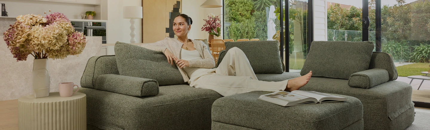 Woman sitting on a green sofa in a modern living room